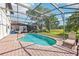 Backyard pool with brick patio, lounge chairs, and fully screened in lanai at 332 Summer Place Loop, Clermont, FL 34714