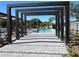 A community pool framed by a decorative pergola, with people swimming and relaxing in an outdoor recreational space at 3432 Tranquil Trl, Kissimmee, FL 34747