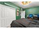 This is a nicely decorated bedroom with dark green walls and white closet doors at 3631 Surrey Dr, Orlando, FL 32812