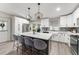 Spacious kitchen features an island with seating, stainless steel appliances, and white cabinetry at 3631 Surrey Dr, Orlando, FL 32812