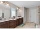 Bathroom featuring double sinks with dark wood cabinets and two mirrors at 3970 Clipstone Pl, Sanford, FL 32773