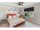 Bright bedroom with a bed, desk, and window with views of the neighborhood at 3970 Clipstone Pl, Sanford, FL 32773