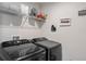 Functional laundry room with a modern washer and dryer set and storage shelves at 3970 Clipstone Pl, Sanford, FL 32773