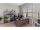 Bright home office featuring a large desk, comfortable chair, shelving and natural light from a large window at 3970 Clipstone Pl, Sanford, FL 32773