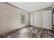 Bright bedroom with wood-look floors, window, and fresh white trim and door at 4425 Mobilaire Dr, Orlando, FL 32822