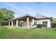 The spacious backyard includes an outdoor kitchen and covered patio for entertaining, set against lush greenery at 4517 Old Carriage Trail, Oviedo, FL 32765