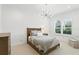This bedroom features an elegant light fixture and a window with lots of natural light at 4517 Old Carriage Trail, Oviedo, FL 32765