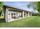 An expansive covered patio with outdoor seating and fireplace overlooks a beautifully landscaped backyard and pool at 4517 Old Carriage Trail, Oviedo, FL 32765