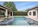 Outdoor pool with a waterfall feature, covered patio area, and lush green landscaping for private enjoyment at 4517 Old Carriage Trail, Oviedo, FL 32765