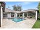 A luxurious backyard featuring a sparkling pool, covered patio, and immaculate landscaping perfect for outdoor living at 4517 Old Carriage Trail, Oviedo, FL 32765