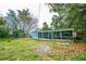 Backyard featuring mature trees, a lawn, and an enclosed porch area at 510 Brighton Way, Casselberry, FL 32707