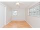 Bedroom with wood-look floors, a ceiling fan, and a window overlooking the backyard at 510 Brighton Way, Casselberry, FL 32707