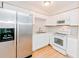 Bright kitchen features white cabinets, stainless refrigerator, and wood-look flooring at 510 Brighton Way, Casselberry, FL 32707