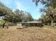 Large backyard featuring mature trees, a screened in pool, and manicured flower beds at 5212 Waterwood Run, Bartow, FL 33830