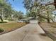 Charming single-story home featuring a long driveway, two-car garage, and mature trees with hanging moss at 5212 Waterwood Run, Bartow, FL 33830