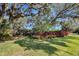 Backyard view showcasing a pool, mature trees, landscaping, and a well-manicured lawn at 5301 Forest Breeze Ct, St Cloud, FL 34771
