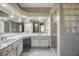 Bathroom with white cabinets, dual sinks, granite countertops, and tiled shower at 5301 Forest Breeze Ct, St Cloud, FL 34771