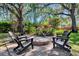 An outdoor fire pit is surrounded by chairs and lush landscaping, creating a cozy entertainment space at 5301 Forest Breeze Ct, St Cloud, FL 34771
