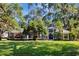 Charming single-story home with a lush front lawn, mature trees, and a welcoming entrance framed by palms at 5301 Forest Breeze Ct, St Cloud, FL 34771