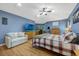Bright main bedroom boasts wood floors, a plush bed, natural light, and relaxing seating area at 5301 Forest Breeze Ct, St Cloud, FL 34771