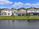 Home exterior overlooking a tranquil pond, featuring a screened-in patio and fenced backyard at 5648 Cedar Chase Dr, St Cloud, FL 34771