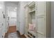 Hallway features built-in storage with seating and shelving, leading to a laundry room with wood-look floors at 5648 Cedar Chase Dr, St Cloud, FL 34771