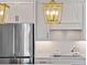 Close-up of a modern kitchen featuring stainless steel appliances, white cabinetry, and stylish backsplash at 5648 Cedar Chase Dr, St Cloud, FL 34771