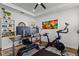 Well-lit office space featuring a desk, shelving, and a Peloton bike for convenient workouts at 5648 Cedar Chase Dr, St Cloud, FL 34771