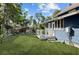 Back yard and deck area of a charming blue home, with lush green lawn at 609 W Osceola St, Clermont, FL 34711