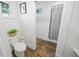 Small bathroom featuring a toilet, shower with curtain, and hardwood floors at 609 W Osceola St, Clermont, FL 34711