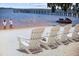 Picturesque beach featuring white Adirondack chairs, soft sand, and tranquil water views at 609 W Osceola St, Clermont, FL 34711