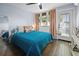 Cozy bedroom with hardwood floors, large window, and stylish blue comforter at 609 W Osceola St, Clermont, FL 34711