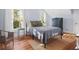 Sunlit bedroom with hardwood floors, a comfortable bed, and a charming side table with a lamp at 609 W Osceola St, Clermont, FL 34711