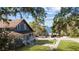 Lovely blue home with a cozy porch, offering a peaceful view of the street and waterfront, shaded by mature trees at 609 W Osceola St, Clermont, FL 34711
