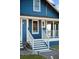 Welcoming front entrance with white steps and railings contrasting against the charming blue home's exterior at 609 W Osceola St, Clermont, FL 34711