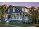 Beautiful two-story blue house with a charming porch, enhanced by soft outdoor lighting for evening appeal at 609 W Osceola St, Clermont, FL 34711