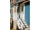 Exterior shot of a blue home's front porch, steps, and white railing at 609 W Osceola St, Clermont, FL 34711