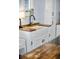 Close up of a kitchen sink with white cabinets and butcher block counters at 609 W Osceola St, Clermont, FL 34711