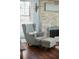 Comfortable wingback chair next to a gray brick fireplace in the living room at 609 W Osceola St, Clermont, FL 34711