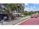 Bustling outdoor restaurant scene with lively seating, lush trees, and colorful umbrellas at 609 W Osceola St, Clermont, FL 34711