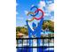 Close-up of a colorful splash pad with spraying water features and a playground on a sunny day at 609 W Osceola St, Clermont, FL 34711