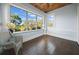 This is a sunroom with beautiful natural light coming through the large windows and a comfortable chair at 609 W Osceola St, Clermont, FL 34711