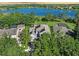 Aerial view of a two-story home featuring solar panels and a well-manicured lawn near a serene lake at 6152 Meriwether, Winter Garden, FL 34787