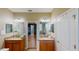 Dual sink bathroom with granite countertops, wood cabinets, mirrors, and neutral paint at 6152 Meriwether, Winter Garden, FL 34787