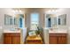 Bathroom featuring double sinks, wood cabinets, a window with a view and neutral walls at 6152 Meriwether, Winter Garden, FL 34787