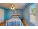 This blue bedroom is filled with light and features hardwood floors, a queen-sized bed, and ceiling fan at 6152 Meriwether, Winter Garden, FL 34787
