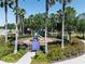Community park with a playground framed by palm trees, lush landscaping, and a welcoming pathway at 6152 Meriwether, Winter Garden, FL 34787