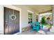 Charming front porch with a gray front door with windows and outdoor furniture at 6152 Meriwether, Winter Garden, FL 34787