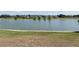 Scenic lake view with lush grassy shoreline and neighborhood in the background at 6152 Meriwether, Winter Garden, FL 34787