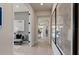 Hallway featuring sleek, glossy floors, modern artwork, and an open view to the dining area at 6324 Dew Drop Loop, St Cloud, FL 34771